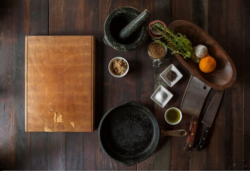 black mortar and pestle beside brown box in top view photography