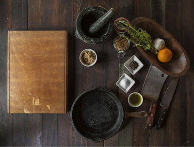 black mortar and pestle beside brown box in top view photography