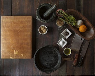 black mortar and pestle beside brown box in top view photography
