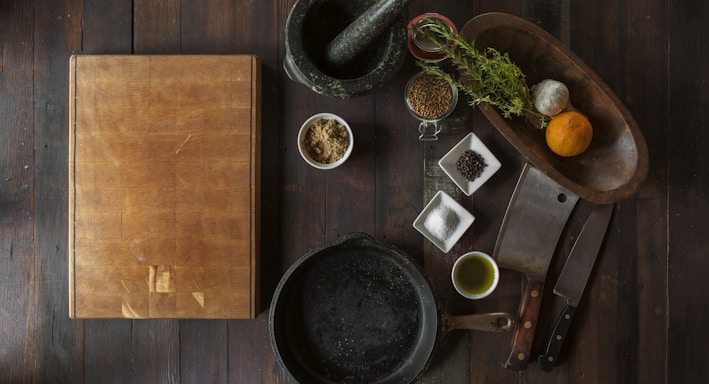 black mortar and pestle beside brown box in top view photography