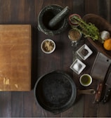 black mortar and pestle beside brown box in top view photography