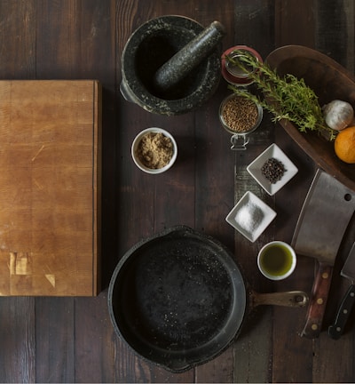 black mortar and pestle beside brown box in top view photography