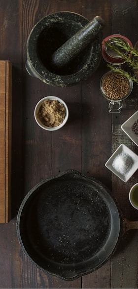 black mortar and pestle beside brown box in top view photography