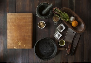 black mortar and pestle beside brown box in top view photography