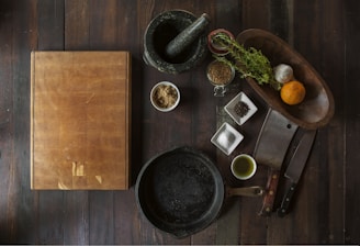 black mortar and pestle beside brown box in top view photography