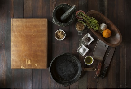 black mortar and pestle beside brown box in top view photography