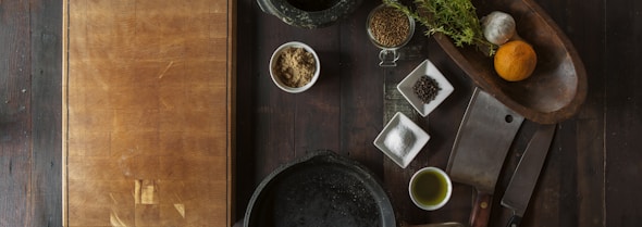 black mortar and pestle beside brown box in top view photography
