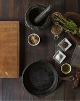 black mortar and pestle beside brown box in top view photography