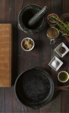 black mortar and pestle beside brown box in top view photography
