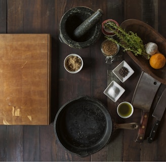 black mortar and pestle beside brown box in top view photography