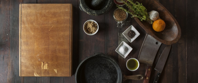 black mortar and pestle beside brown box in top view photography