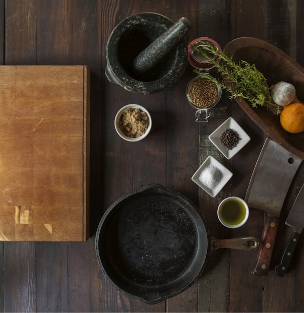black mortar and pestle beside brown box in top view photography
