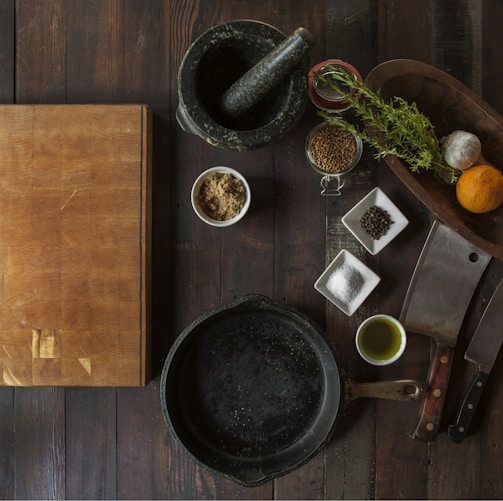 black mortar and pestle beside brown box in top view photography