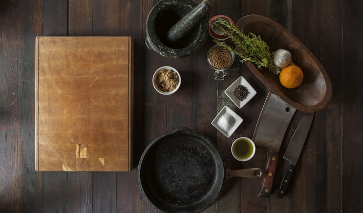 black mortar and pestle beside brown box in top view photography