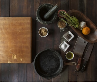 black mortar and pestle beside brown box in top view photography