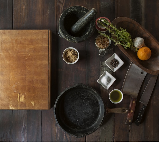 black mortar and pestle beside brown box in top view photography