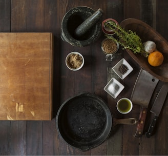 black mortar and pestle beside brown box in top view photography
