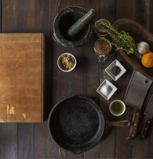 black mortar and pestle beside brown box in top view photography