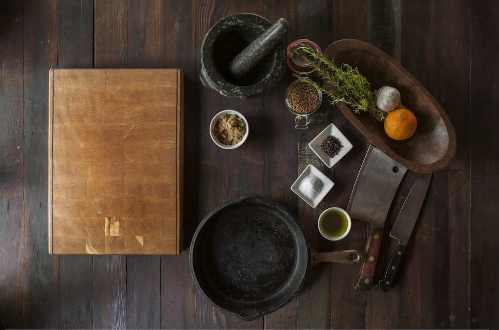 black mortar and pestle beside brown box in top view photography