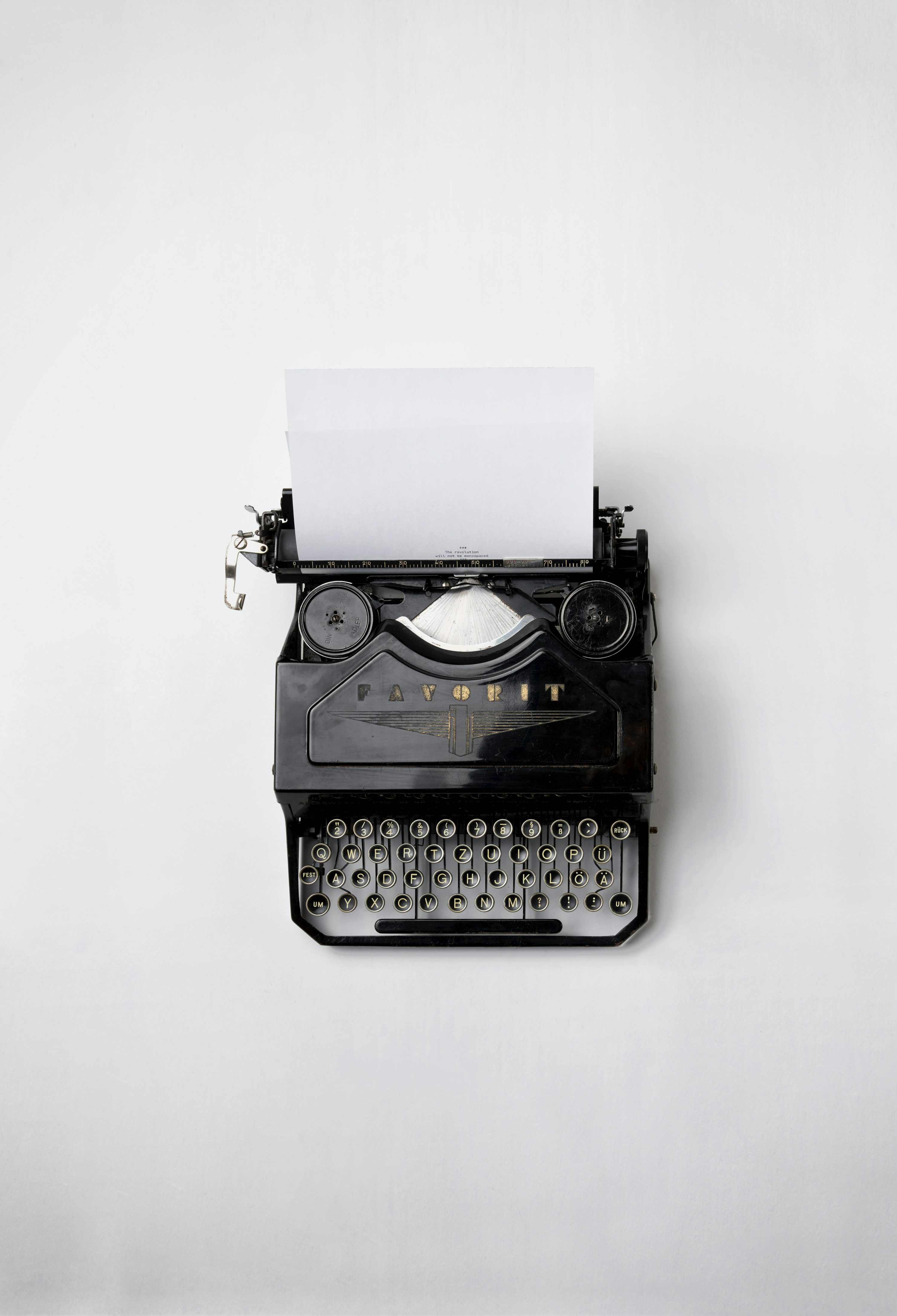 A black typewriter with a white piece of paper inside it.