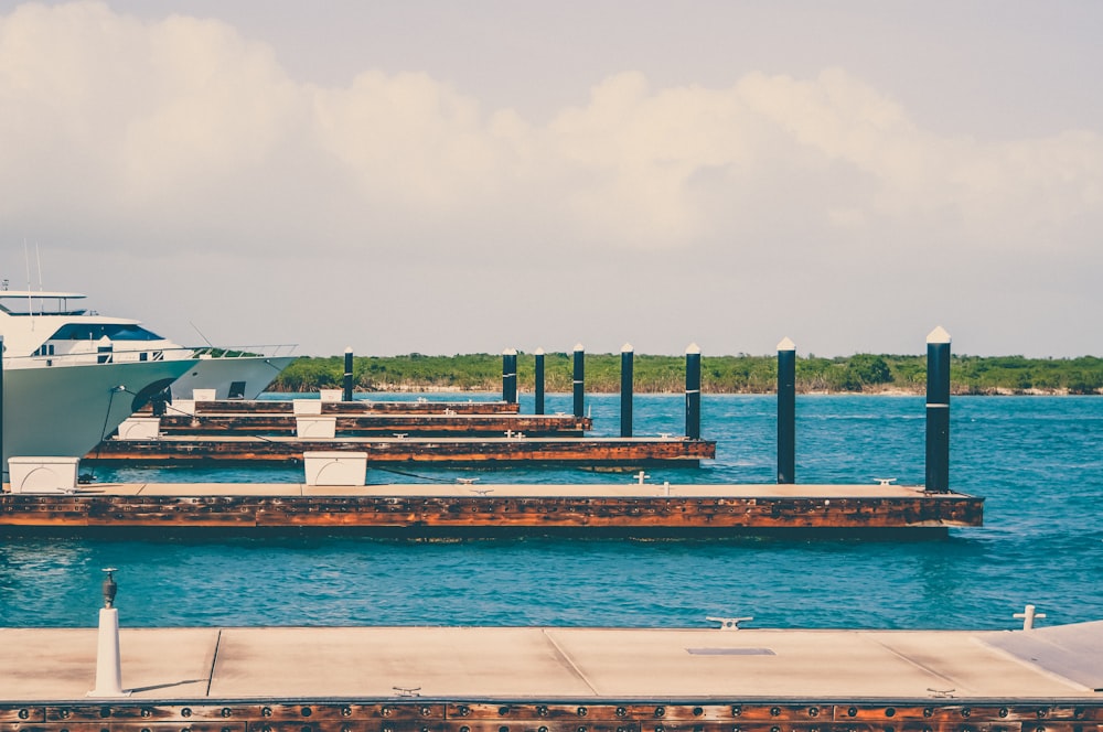 boats on dock under cloudy sky at daytime