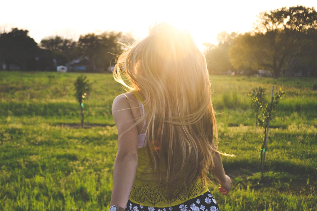 Sunlight welcomes blonde girl by MMA Ninja woman walking on lawn with trees