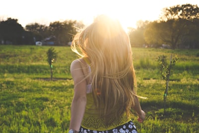 woman walking on lawn with trees