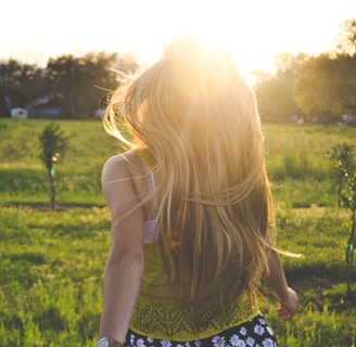 woman walking on lawn with trees