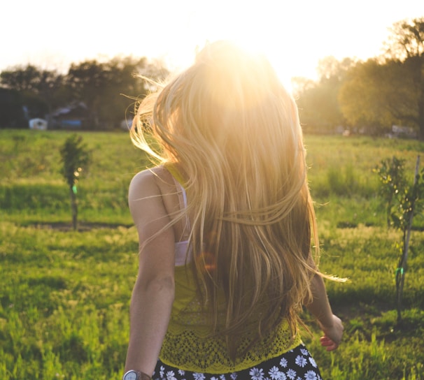 woman walking on lawn with trees