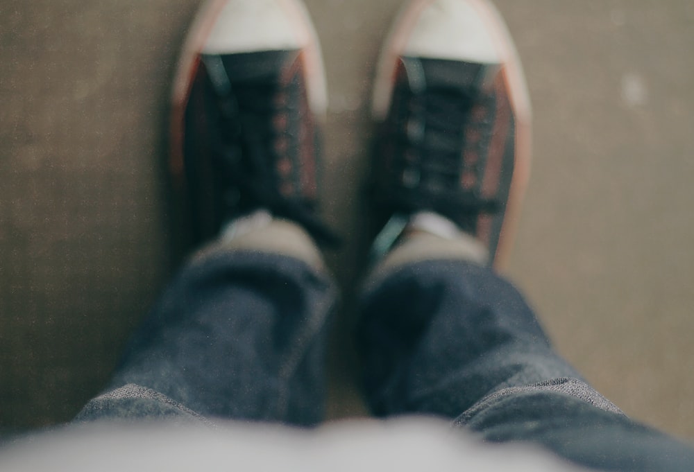 Person, die weiß-schwarze Low-Top-Turnschuhe trägt