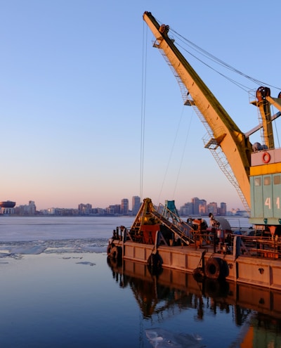 yellow and blue commercial machine near body of water