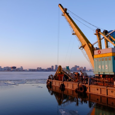 yellow and blue commercial machine near body of water