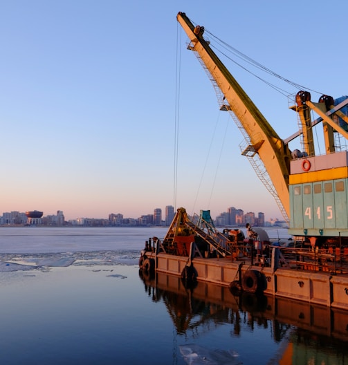 yellow and blue commercial machine near body of water