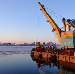yellow and blue commercial machine near body of water
