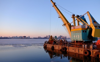 yellow and blue commercial machine near body of water