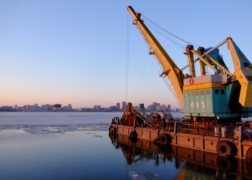 yellow and blue commercial machine near body of water