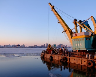 yellow and blue commercial machine near body of water