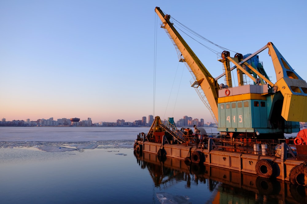 yellow and blue commercial machine near body of water