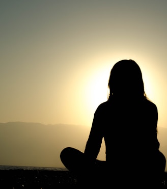 A calm, inspiring scene of a person meditating at sunrise to symbolize mental clarity and personal growth.