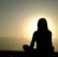 A serene setting with a person meditating outdoors during sunrise, symbolizing spiritual peace and healing.