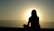 A serene setting with a person meditating outdoors during sunrise, symbolizing spiritual peace and healing.