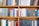 A bookshelf filled with a variety of academic and professional books, arranged neatly in rows. The spines display titles in different languages and cover various topics. Some books are thicker, while others are thinner, showing diversity in publishing styles.
