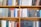 A bookshelf filled with a variety of academic and professional books, arranged neatly in rows. The spines display titles in different languages and cover various topics. Some books are thicker, while others are thinner, showing diversity in publishing styles.