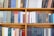 A bookshelf filled with a variety of academic and professional books, arranged neatly in rows. The spines display titles in different languages and cover various topics. Some books are thicker, while others are thinner, showing diversity in publishing styles.