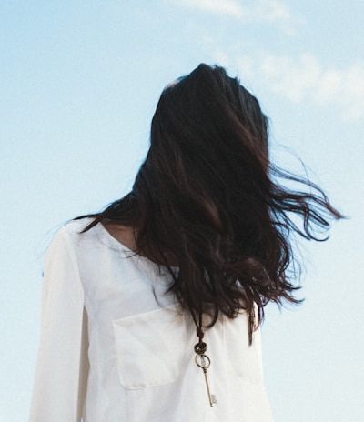 woman in white shirt under cloudy sky
