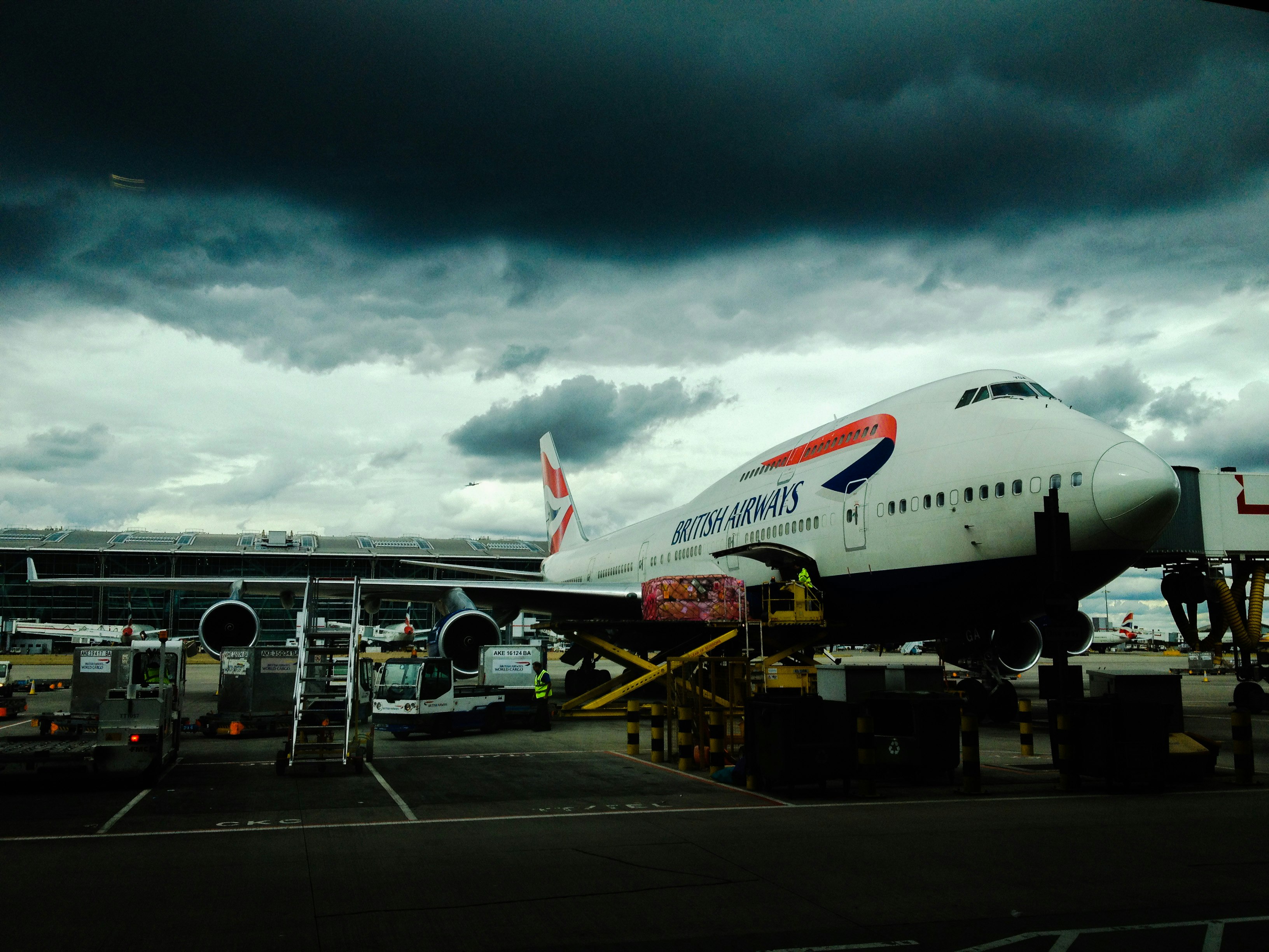 white and red airplane with cumulonimbus cloud