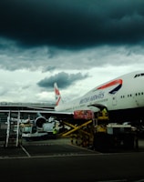 white and red airplane with cumulonimbus cloud