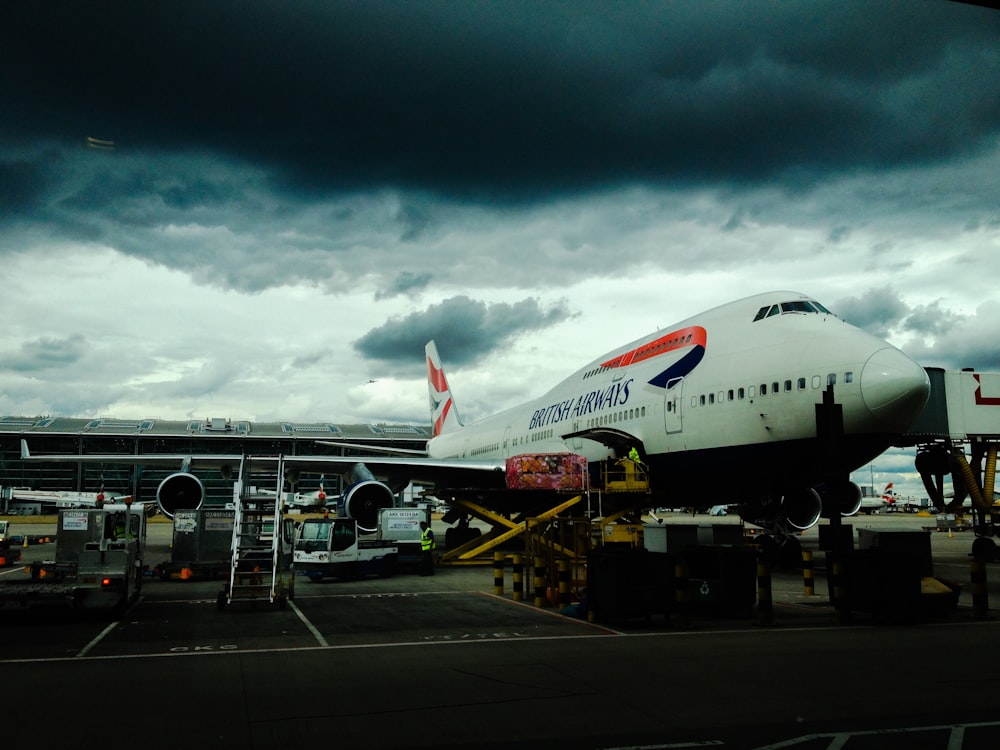 white and red airplane with cumulonimbus cloud