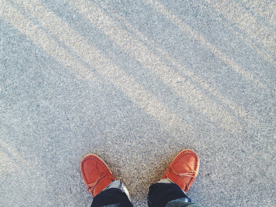 person wearing pair of brown boat shoes on floor person wearing pair of brown boat shoes on floor