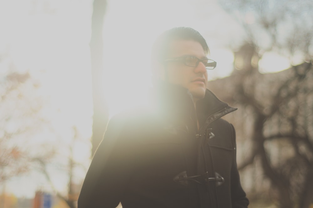 homme portant une veste noire et des lunettes